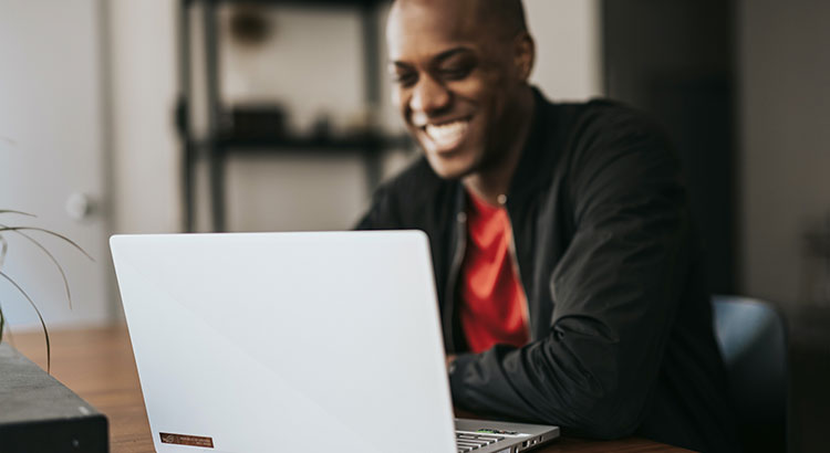 person smiling at laptop